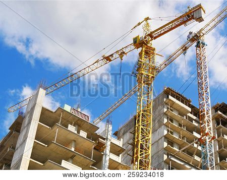 Skyscraper Construction. Two Cranes Near Building Under Construction. Construction Site.