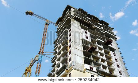 Construction Building Against Blue Sky. Cranes Nesr Building. Construction Site.