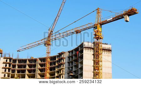Two Tower Cranes Near Building. Construction Site. Building Under Construction.