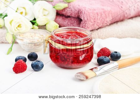 Jar Of Fruit Beauty Care Mask Of Mashed Red Raspberies, Flowers And Towels Spa Background, Fresh Ber