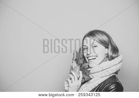 Girl With Orange Leaves On Blue Background. Happy Model With Stylish Hair In Scarf. Beauty And Fashi