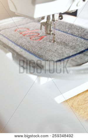 Diagonal Detail View On A Modern Computerised Sewing Machine And Embroidery Unit  Stitching Red Lett