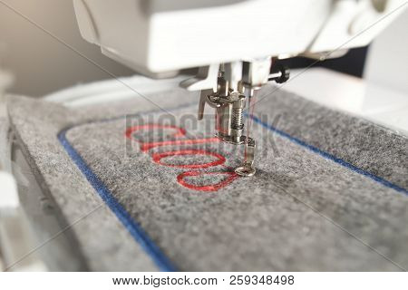 Diagonal Detail View On A Modern Computerised Sewing Machine And Embroidery Unit  Stitching Red Lett