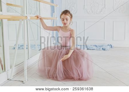 Young Classical Ballet Dancer Girl In Dance Class. Beautiful Graceful Ballerina Practice Ballet Posi