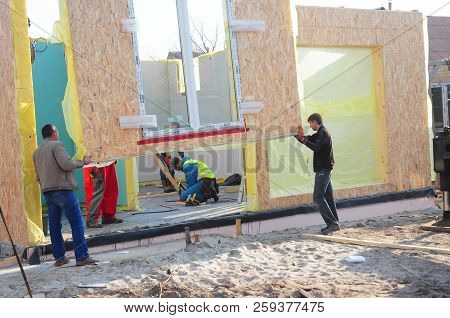 Kyiv, Ukraine - July, 10, 2018: 
Contractors Installing Modular Frame Plywood Board Panel Walls Hous