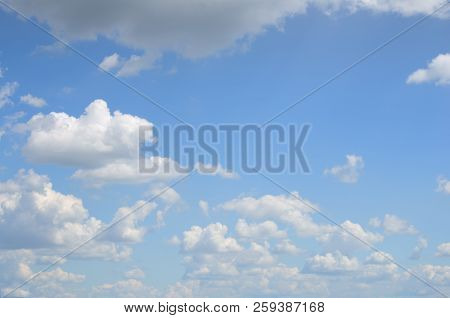 Blue Sky With Many Of White And Gray Clouds Above The Water On Summer Day As A Natural Background Fo
