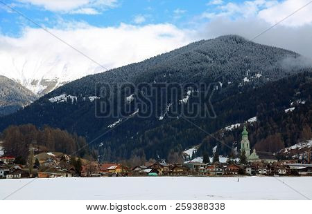 Panorama Of The Town Of Dobbiaco In Italy And In The Background The Snow-capped Mountains