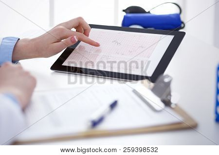 Woman Doctor Using Tablet Computer While Standing Straight In Hospital Closeup. Healthcare, Insuranc