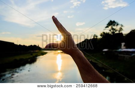 Enjoy Sunset Above River Surface. River Sun Reflection. Catch Last Sunbeam. Male Hand Pointing At Su