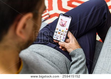 London, Uk - Sep 21, 2018: Man Using The New Smiling Pig Ar Memoji Emoji Face On Apple Iphone Xs Wit