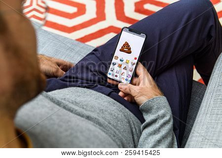 London, Uk - Sep 21, 2018: Man Using The New Pile Of Poo Ar Memoji Emoji Face On Apple Iphone Xs Wit