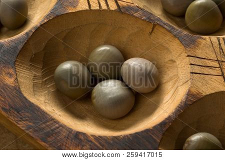 Traditional African oware game with seeds isolated on white background