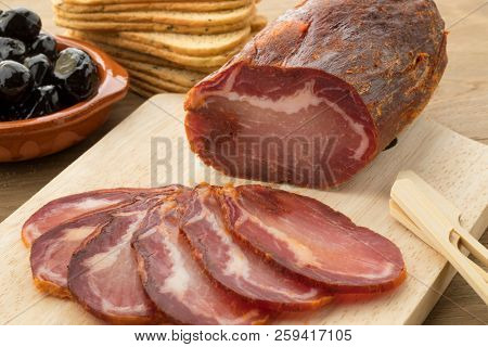 Piece of spanish Lomo Embuchado meat and slices