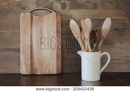 Crockery, White Utensils And Other Different Stuff On Wooden Tabletop. Kitchen Still Life As Backgro