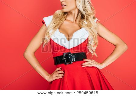 Partial View Of Sexy Santa Girl In Christmas Dress Standing Waith Hands On Waist Isolated On Red Bac