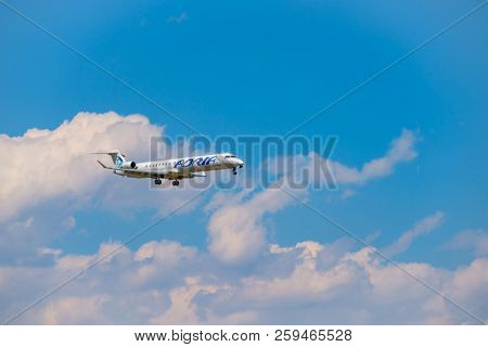 Zurich, Switzerland - July 19, 2018: Adria airlines airplane flying in the blue cloudy sky,  preparing for landing at day time in Zurich nternational airport