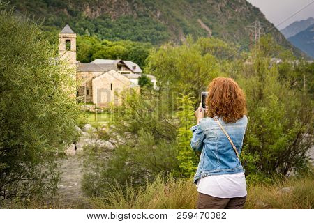 Girl Taking A Picture With A Smartphone Of The Romanesque Church Of Sant Feliu De Barruera, In Catal