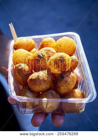 A Female Hand Holding A Box Of Lokma, Typical Turkish Fritter.
Also Know As Arabic Loqma Or Luqaimat