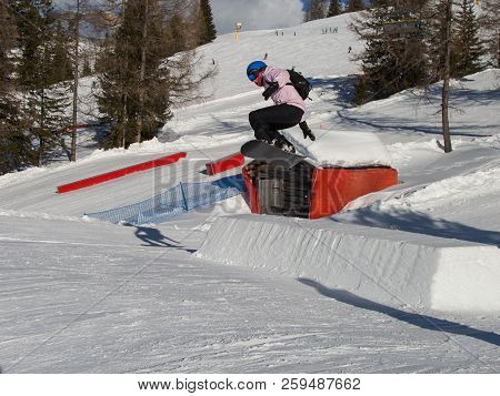 Snowboarder In Action: Jumping In The Mountain Snowpark.