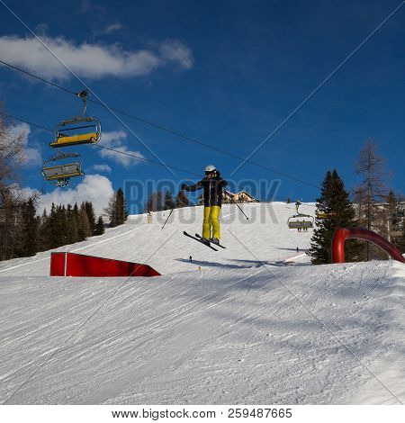 Skier In Action: Ski Jumping In The Mountain Snowpark.