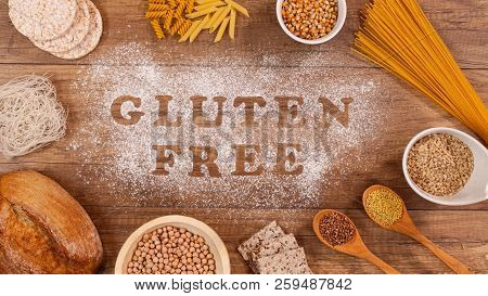 Gluten Free Products Gathering Around Words Written In Special Flour On The Table - Top View
