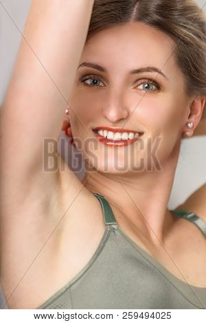 Portrait Of A Beautiful Young Smiling Woman Close-up. She Shows A Smooth Armpit