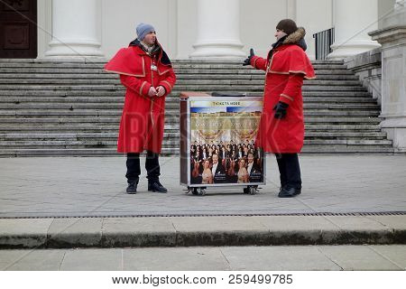 Vienna, Austria, 09-12-2017: Two People Next An Ad Avertising A Vienna Concert.
