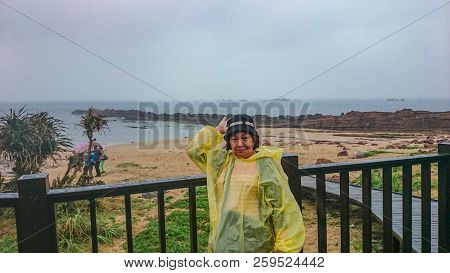 Happy Old Asian Women Wear A Rain Roat And Travel In Taipei Yehliu Geopark In Rainy Day,taiwan Trave