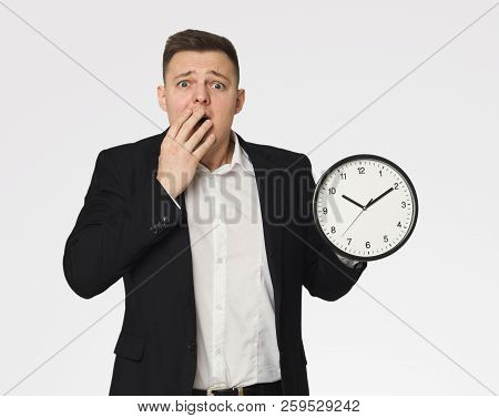 Late For Business Meeting, Shocked Man In Suit Holding Clock, Time Management Concept
