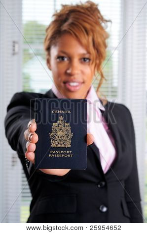 Dość African American kobieta trzyma jej paszport kanadyjski, płytkiej ostrości na paszport