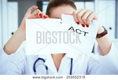 Hands Of Female Medicine Doctor Ripping Contract. Photo With Depth Of Field.