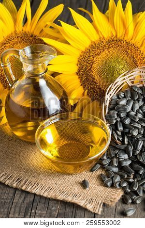 Sunflower Oil And Sunflower Seeds In Small Sack On Traditional Rustic Wooden Background. Organic And