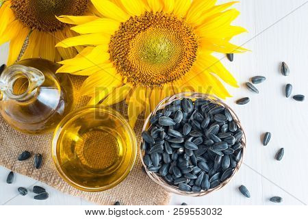 Sunflower Oil And Sunflower Seeds In Small Sack On Traditional Rustic Wooden Background. Organic And