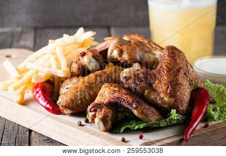 Close-up Photo Of Bbq Chicken Wings With Fries And Beer. Barbeques Meat With Sauces, Ketchup, Mayonn