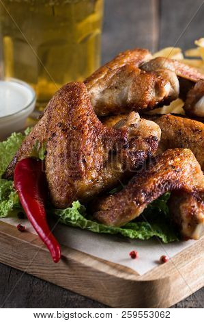 Close-up Photo Of Bbq Chicken Wings With Fries And Beer. Barbeques Meat With Sauces, Ketchup, Mayonn