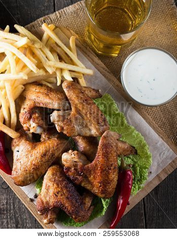 Close-up Photo Of Bbq Chicken Wings With Fries And Beer. Barbeques Meat With Sauces, Ketchup, Mayonn