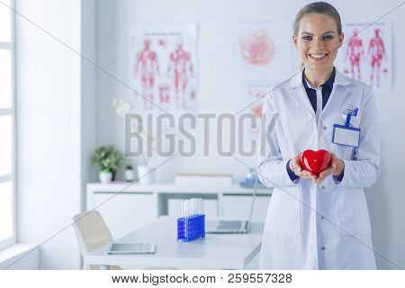 A Doctor With Stethoscope Examining Red Heart, Isolated On White Background