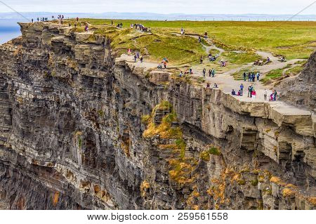 People Walking Over Cliffs Of Moher