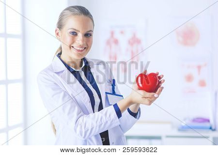 A Doctor With Stethoscope Examining Red Heart, Isolated On White Background