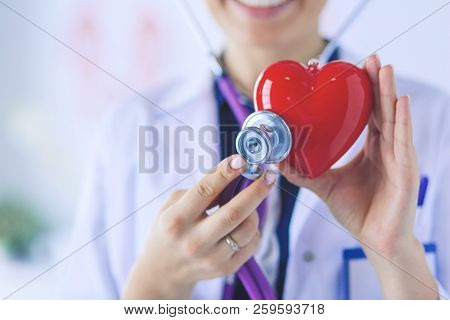 A Doctor With Stethoscope Examining Red Heart, Isolated On White Background