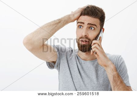 Concerned And Troubled Anxious Boyfriend Receiving Bad News During Phone Call Holding Arm On Forehea