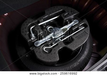 Car Jack And Wheel Changing Tool Kit In Spare Tyre Of Car, Automotive Part Concept.