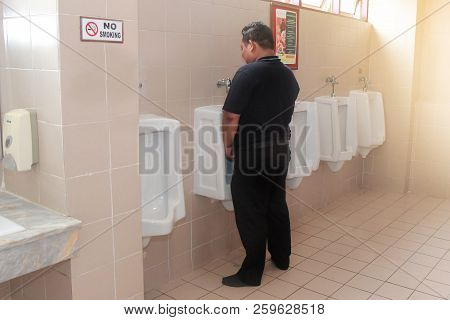 Tak,thailand,21 Sep 2018, The Man In Black Standing For Urinal Pissing At Urine Bidet Within  The Pu