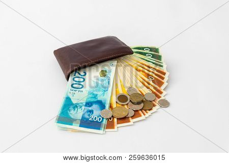 Вrown  Leather Wallet And Stack Of Banknotes And Several Coins Of New Israeli Shekels Isolated On Wh