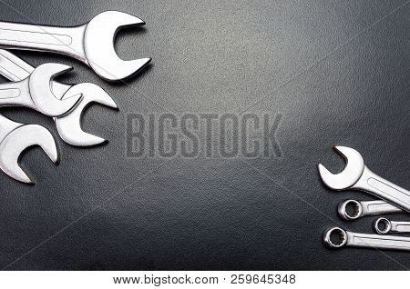 Metal Flat Wrenches Lying On A Black Table, Top View, Flat Lay.