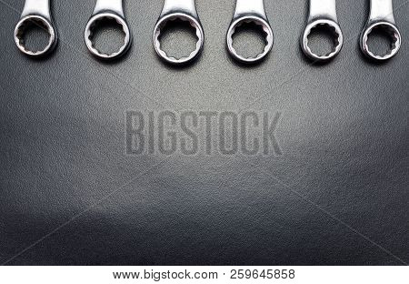 Metal Flat Wrenches Lying On A Black Table, Top View, Flat Lay.