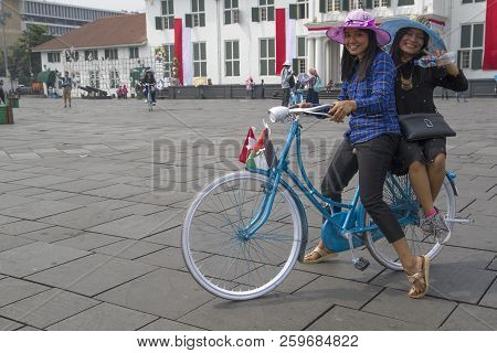 Jakarta,java ,indonesie -10 Augustus ,2018: Two Cycling Ladies With A Hat On A Square In Jakarta On 