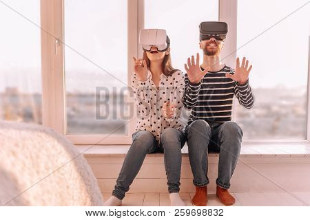 Creative Couple Sitting On The Windowsill At Sunset