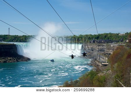 Niagara Falls, Ontario, Canada - May 21st 2018: Two People Taking Zipline Ride At Niagara Falls In S