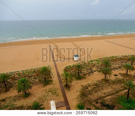 Aerial View Of Gandia Beach In Spain, With Wooden Footbridges Palm Trees And Vegetation And With Spo